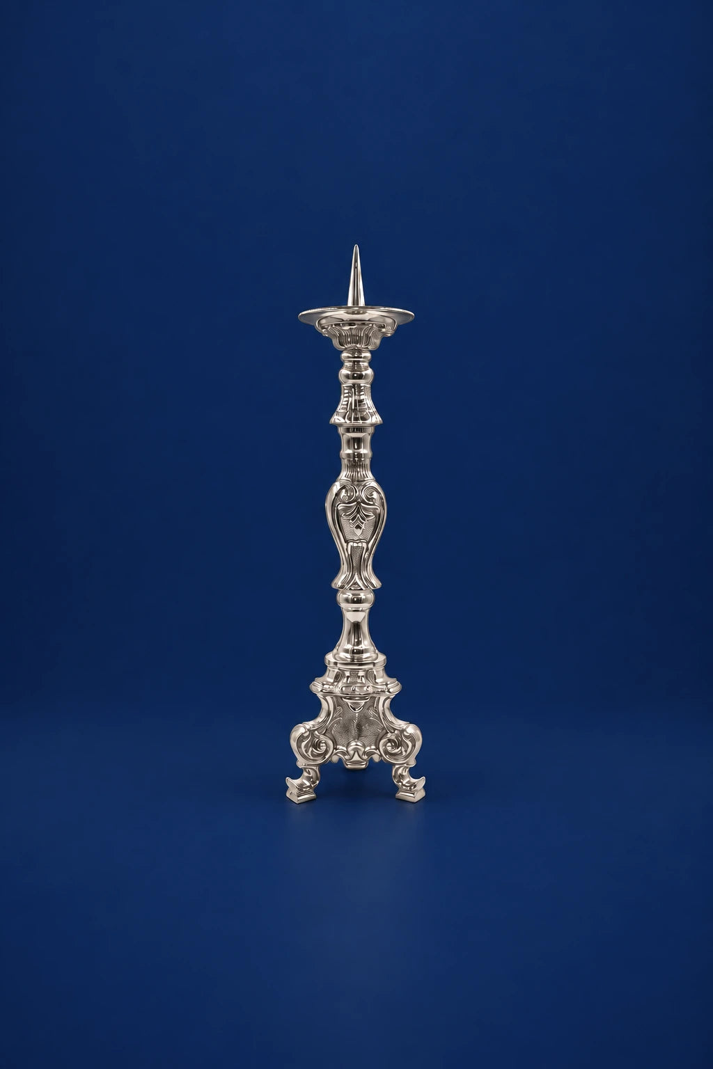 Full-length nickel-plated brass candlestick with ornate stem and three-footed base