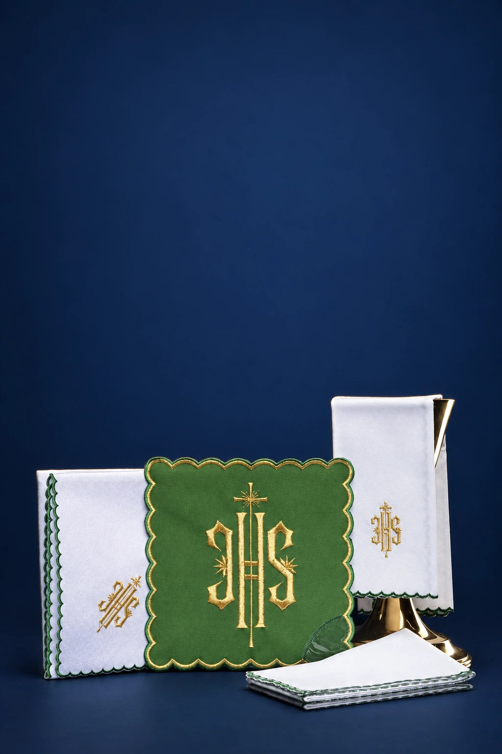 Green embroidered altar linen set with IHS monogram and gold edging, shown front view with folded cloths and veil cover