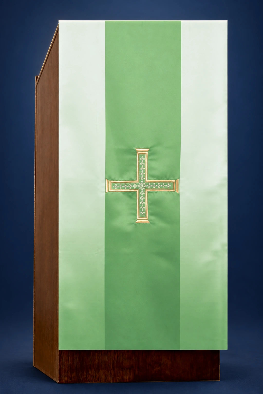 Green lectern cover with central embroidered cross and pale vertical side panels, front view