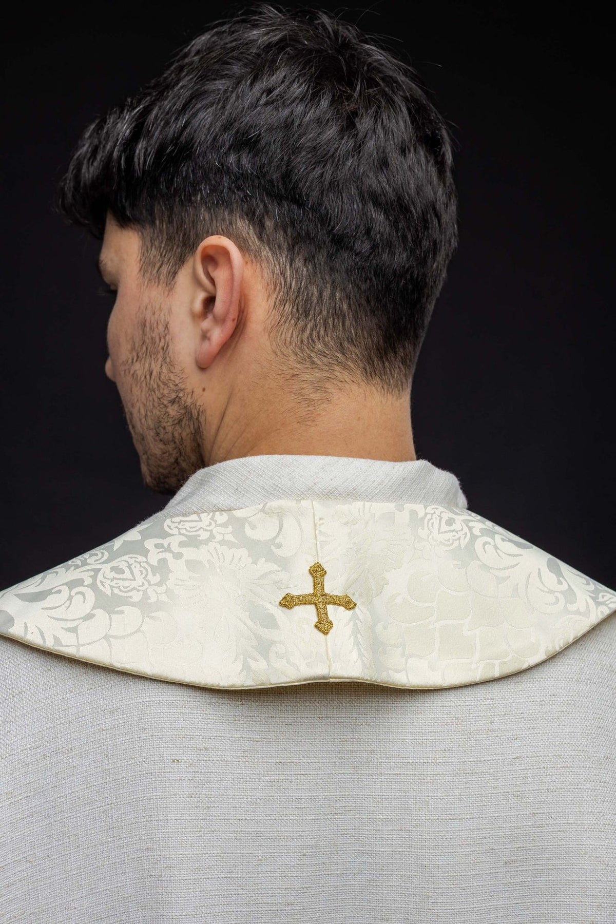 Roman stole back view showing ecru jacquard fabric and a central gold cross