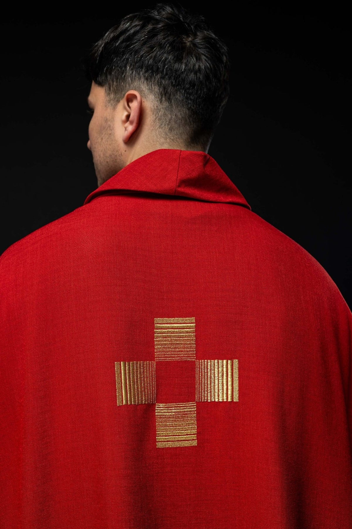 Red chasuble back close-up with a single gold embroidered cross