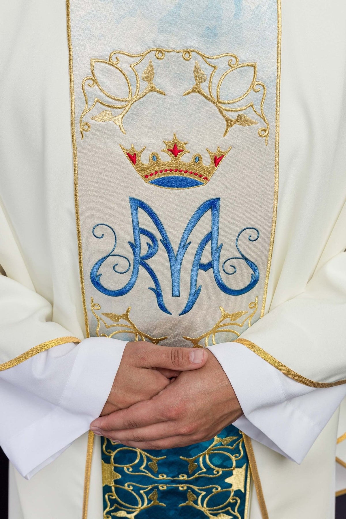 Close-up of embroidered Marian symbol and crown on the ecru chasuble orphrey