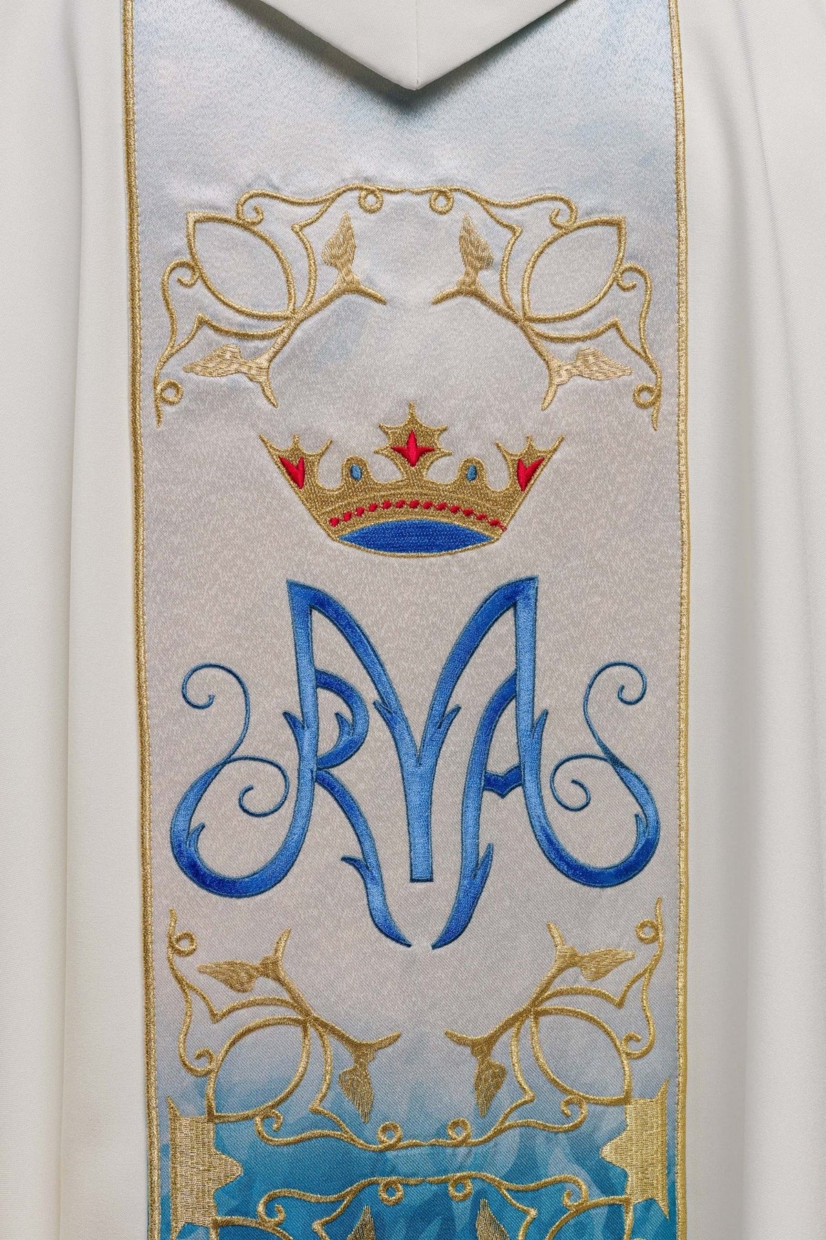 Close-up of embroidered Marian symbol, crown and floral motifs on the chasuble front