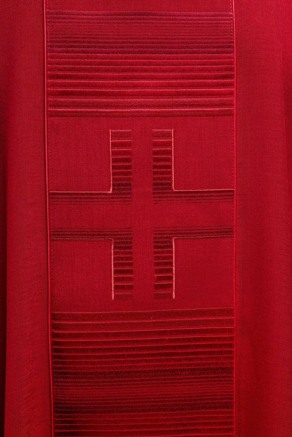 Red chasuble embroidery close-up showing a large cross and red trim