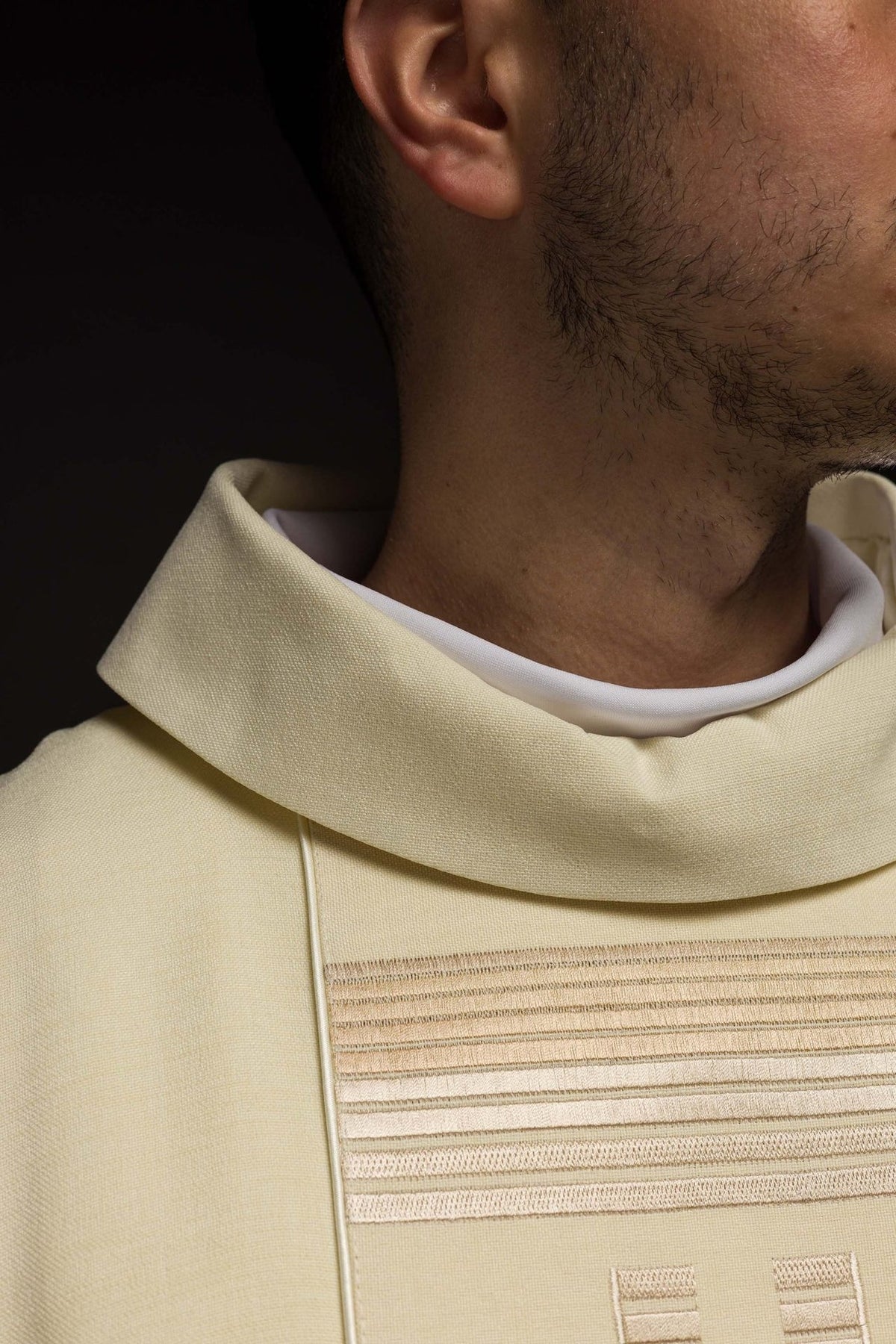 Ecru chasuble close-up showing stand-up collar and upper front embroidery