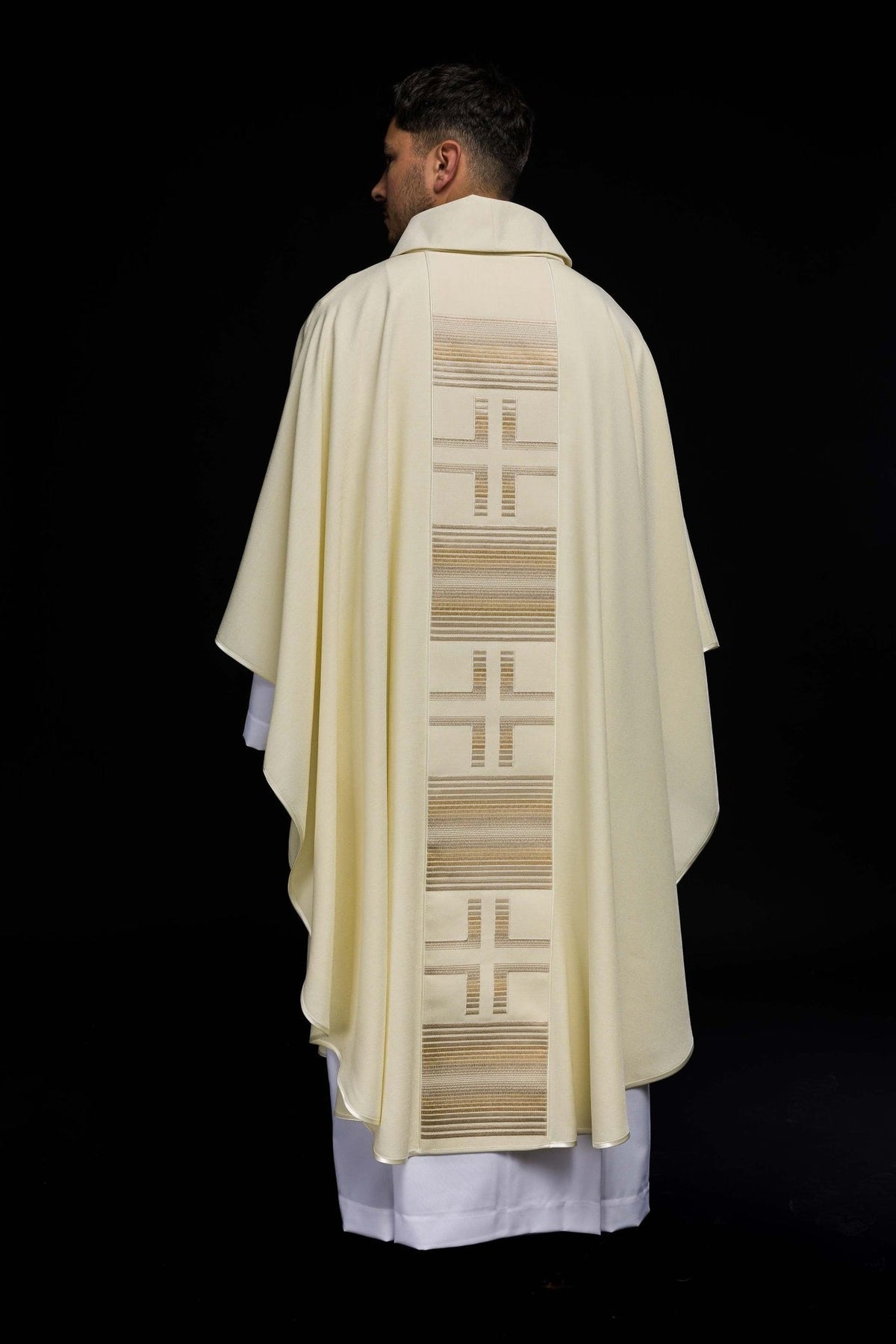 Ecru chasuble full back view with repeated cross embroidery and striped trim