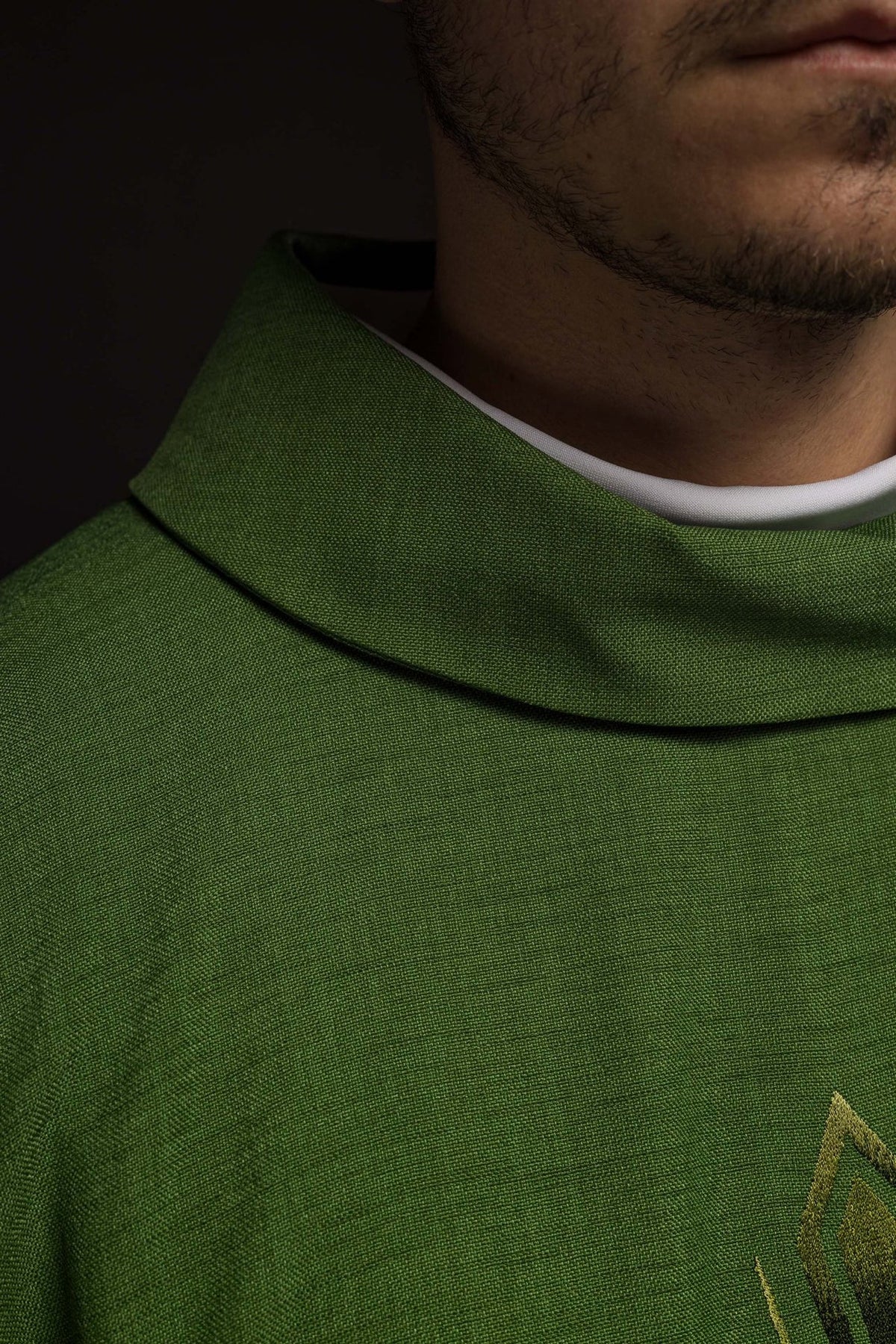 Green chasuble close-up showing the stand-up collar and woven fabric