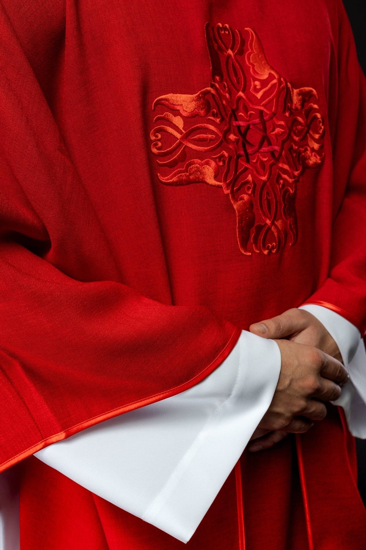 Red chasuble side close-up with cross embroidery and satin sleeve trim