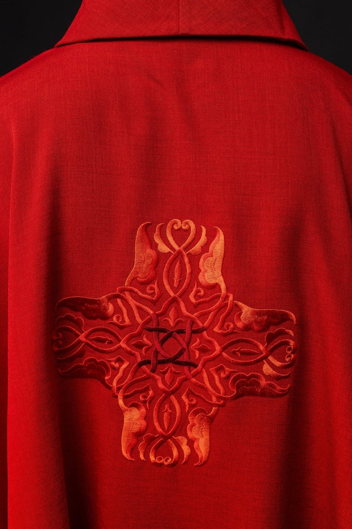 Red chasuble back close-up with ornate cross embroidery
