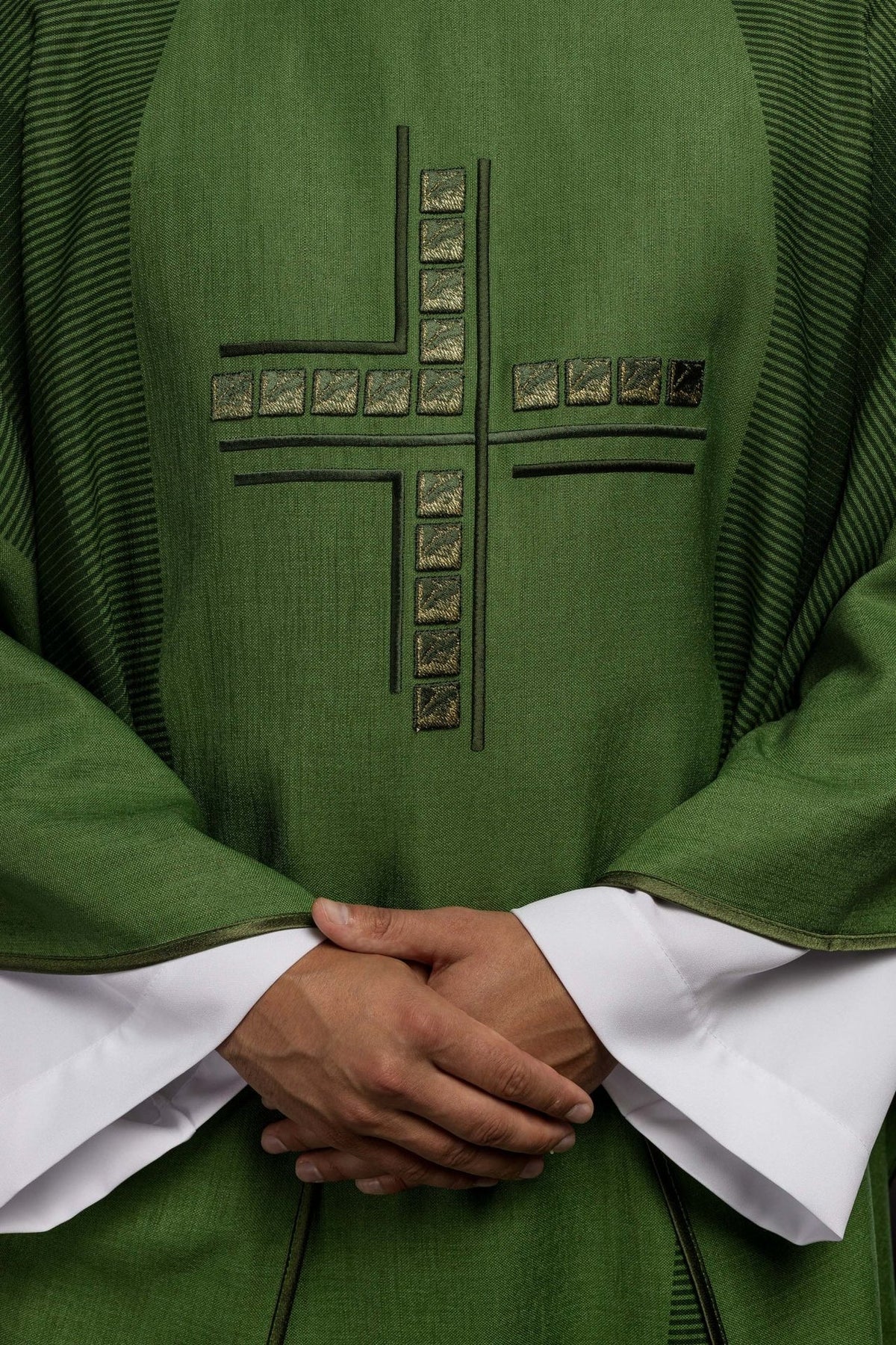 Embroidered cross detail on the green chasuble front