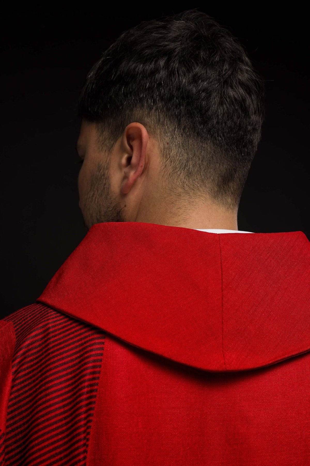 Red chasuble close-up of striped sleeve and red stand-up collar