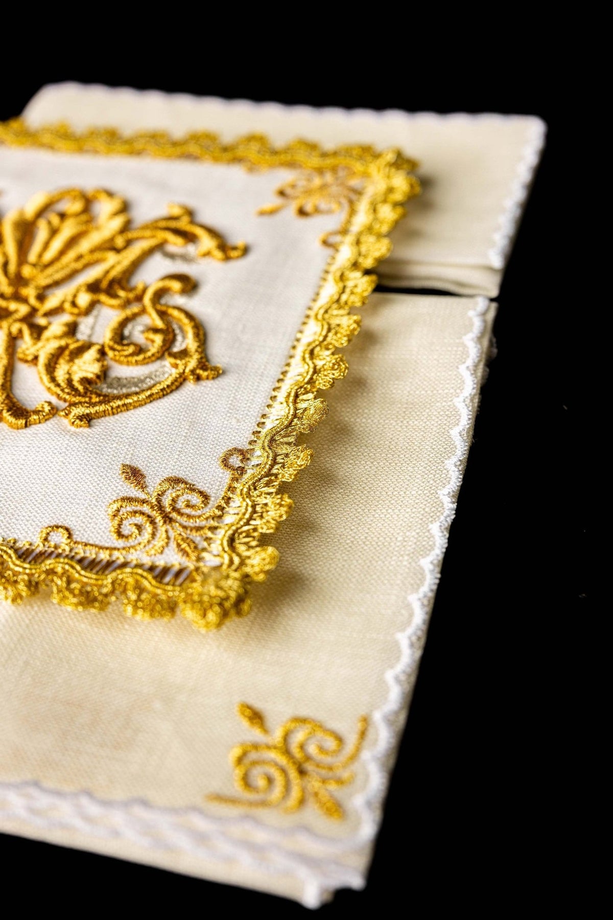 Altar linen set detail showing white linen, gold embroidered border and corner motifs