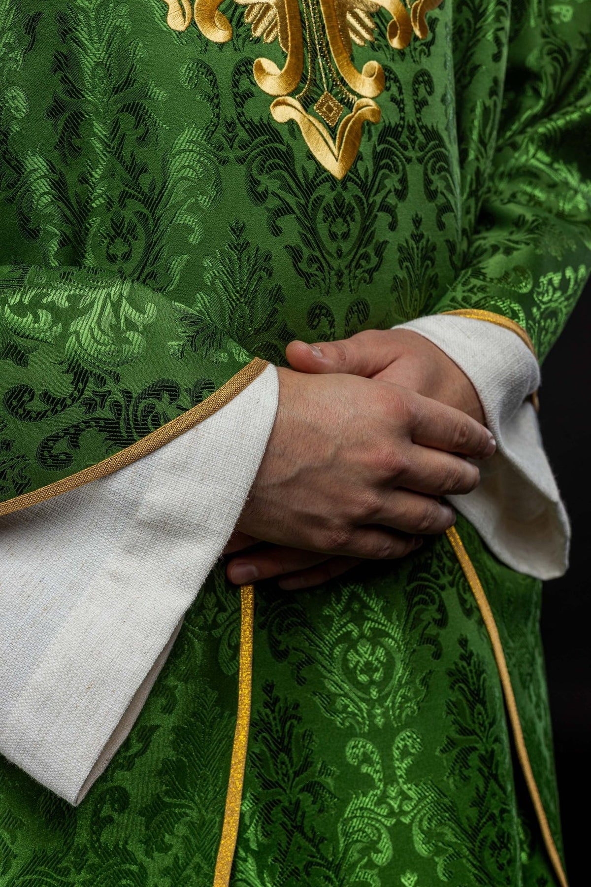 Green chasuble detail showing gold embroidered cross and gold trim
