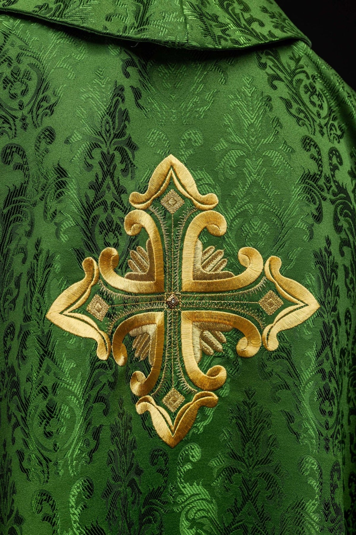 Green chasuble stand-up collar and gold embroidered cross close-up