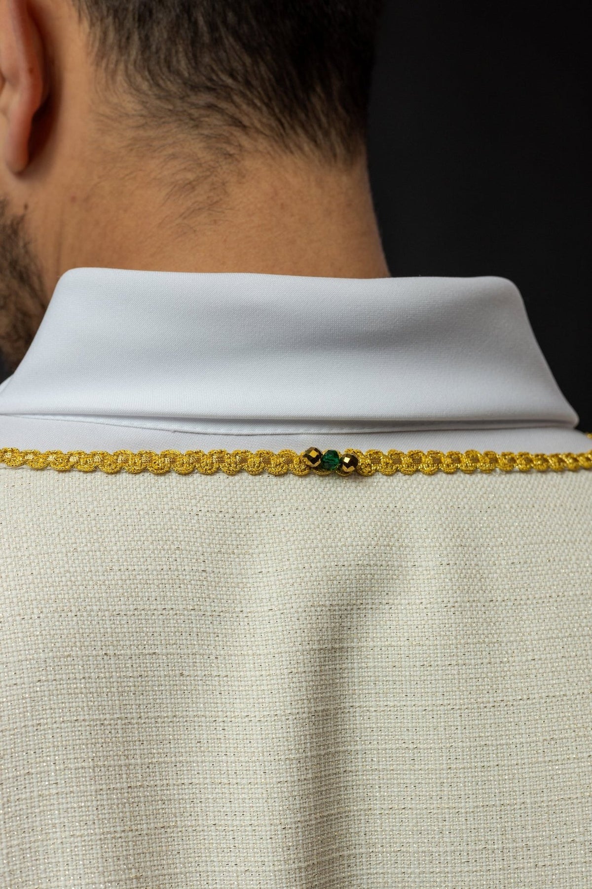 Handcrafted dalmatic close-up of ivory collar with gold trim and natural stones