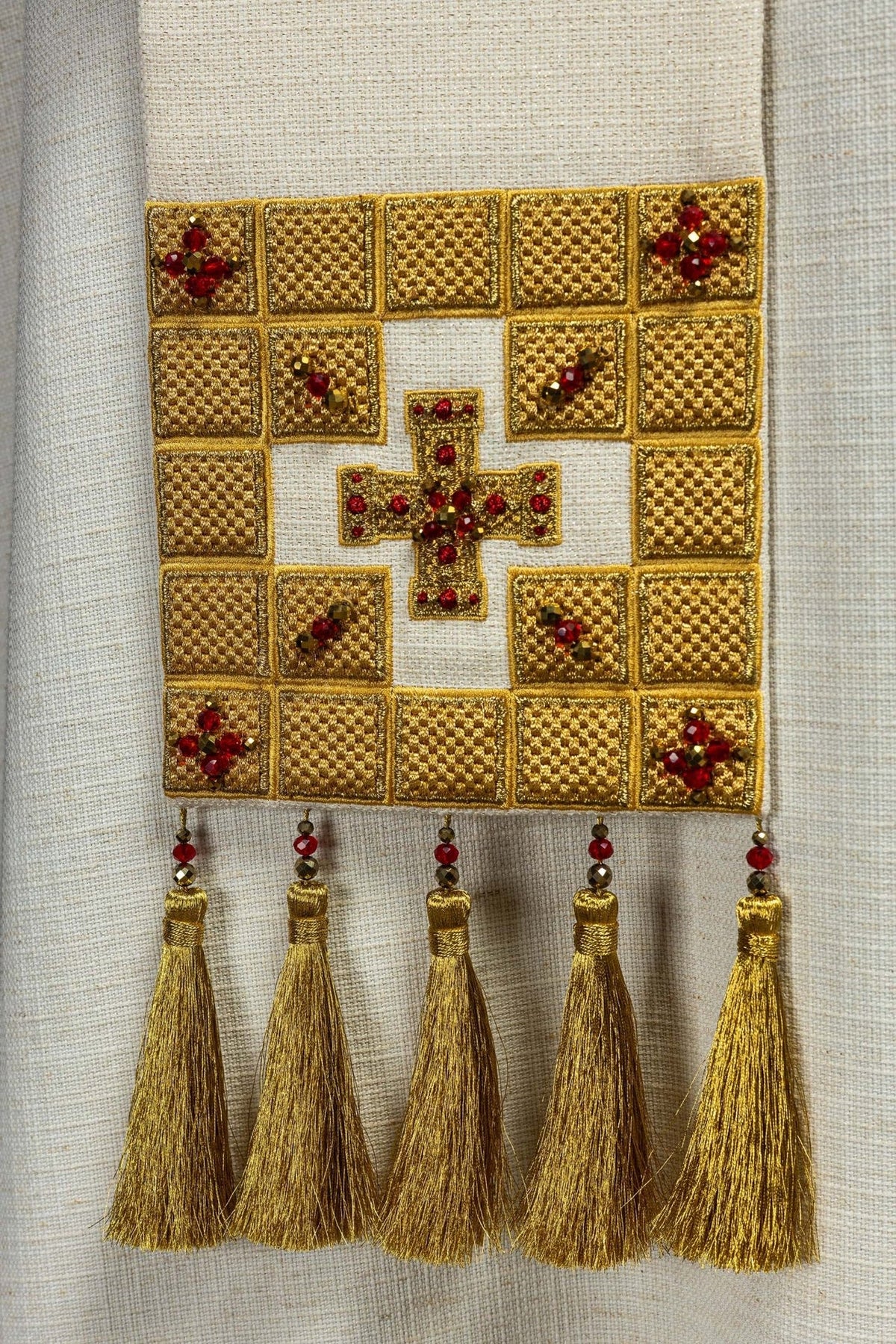 Stole end detail with gold cross embroidery, red stones and five gold tassels
