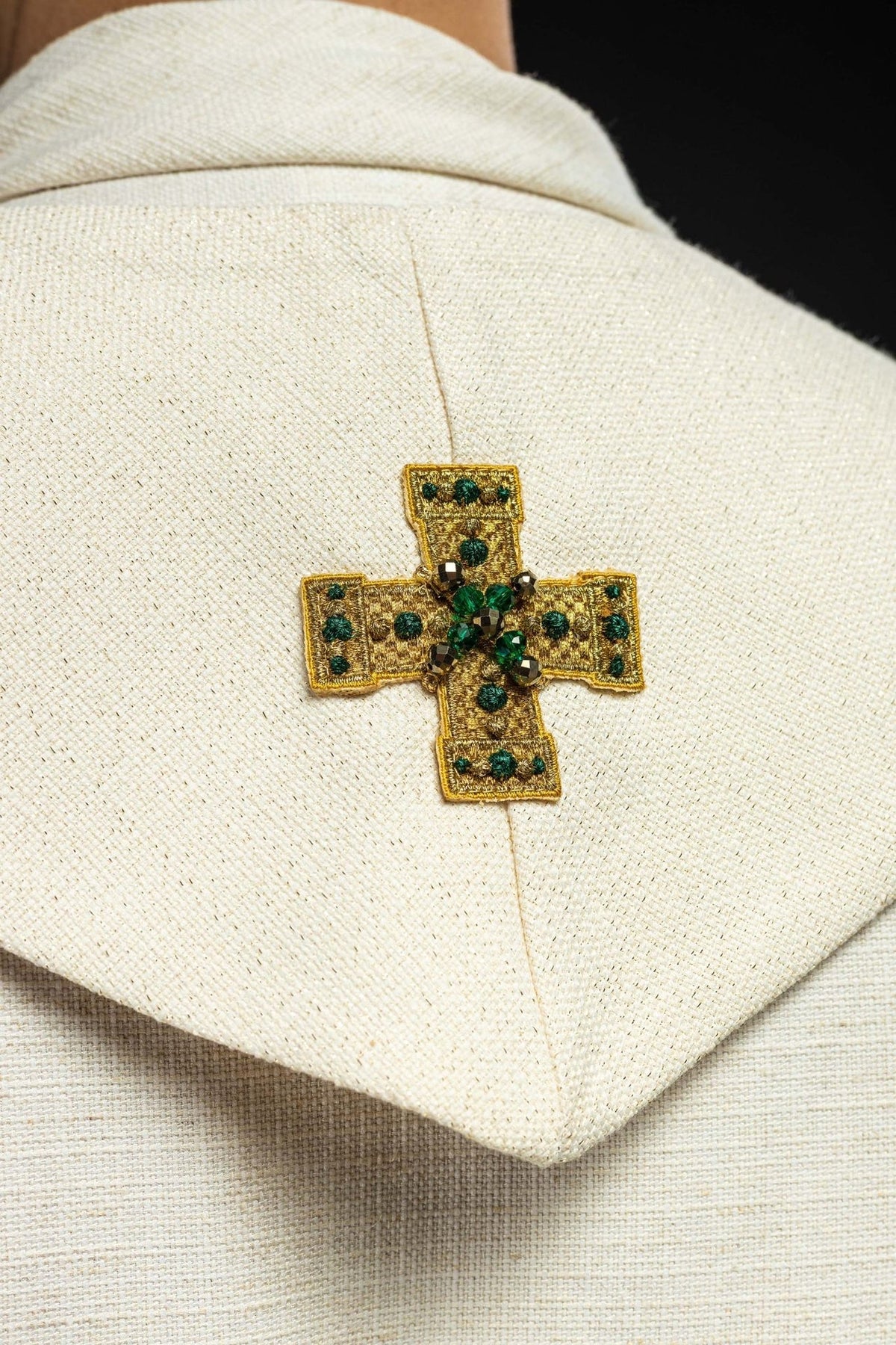 Stole cross close-up with gold embroidery and green stones