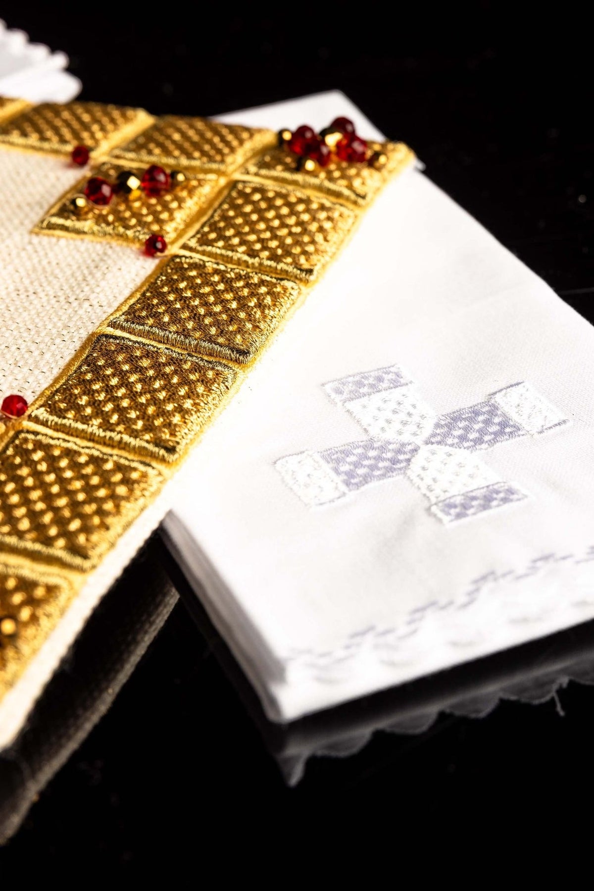 Altar linen set detail showing gold embroidered border and white fabric with cross