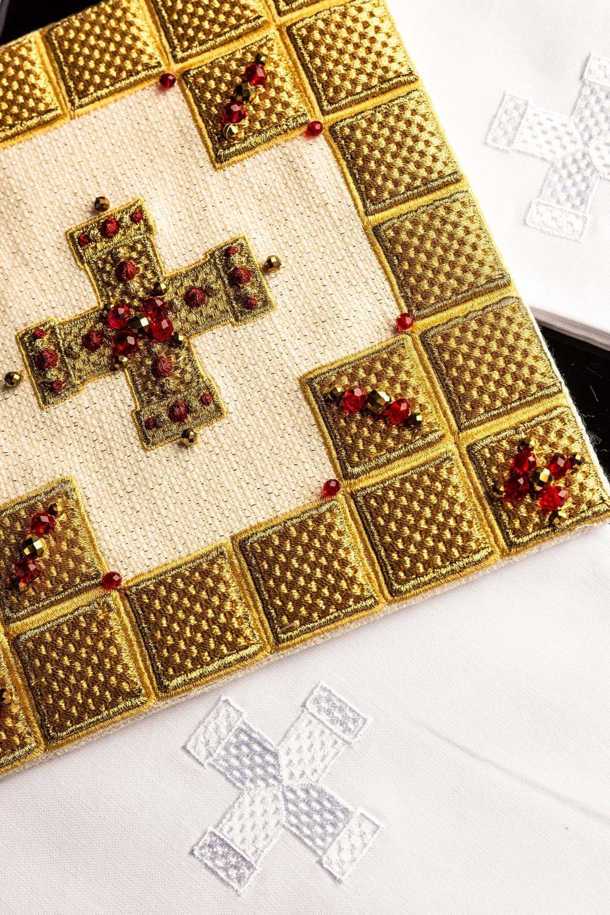 Altar linen set detail of white fabric with embroidered cross and gold border