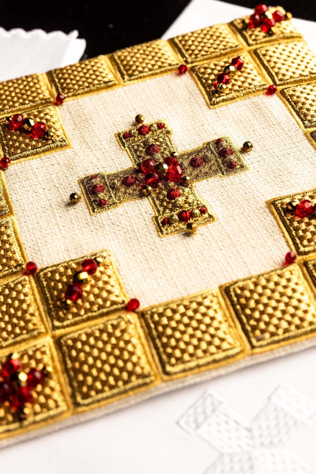 Altar linen set close-up showing central gold embroidered cross with red stones