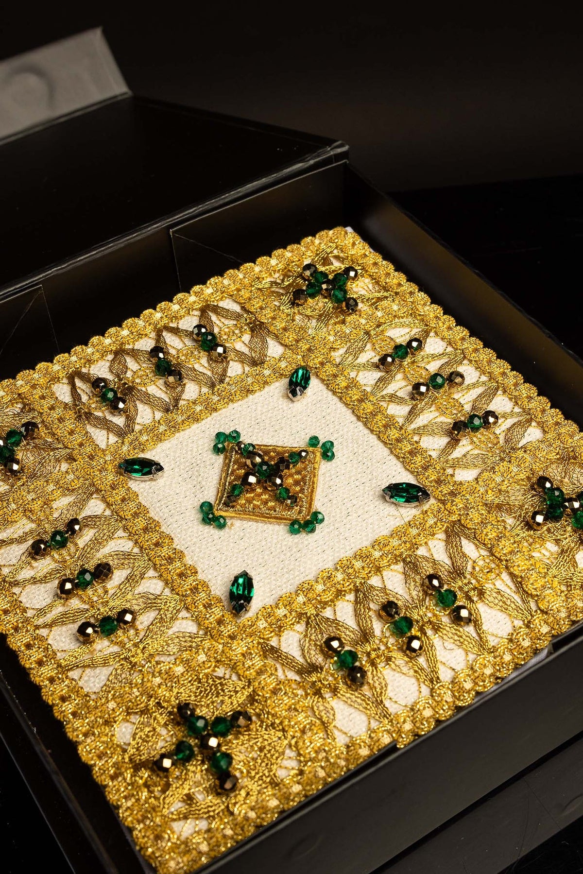Altar linen set displayed in its open presentation box with gold embroidery and green stones