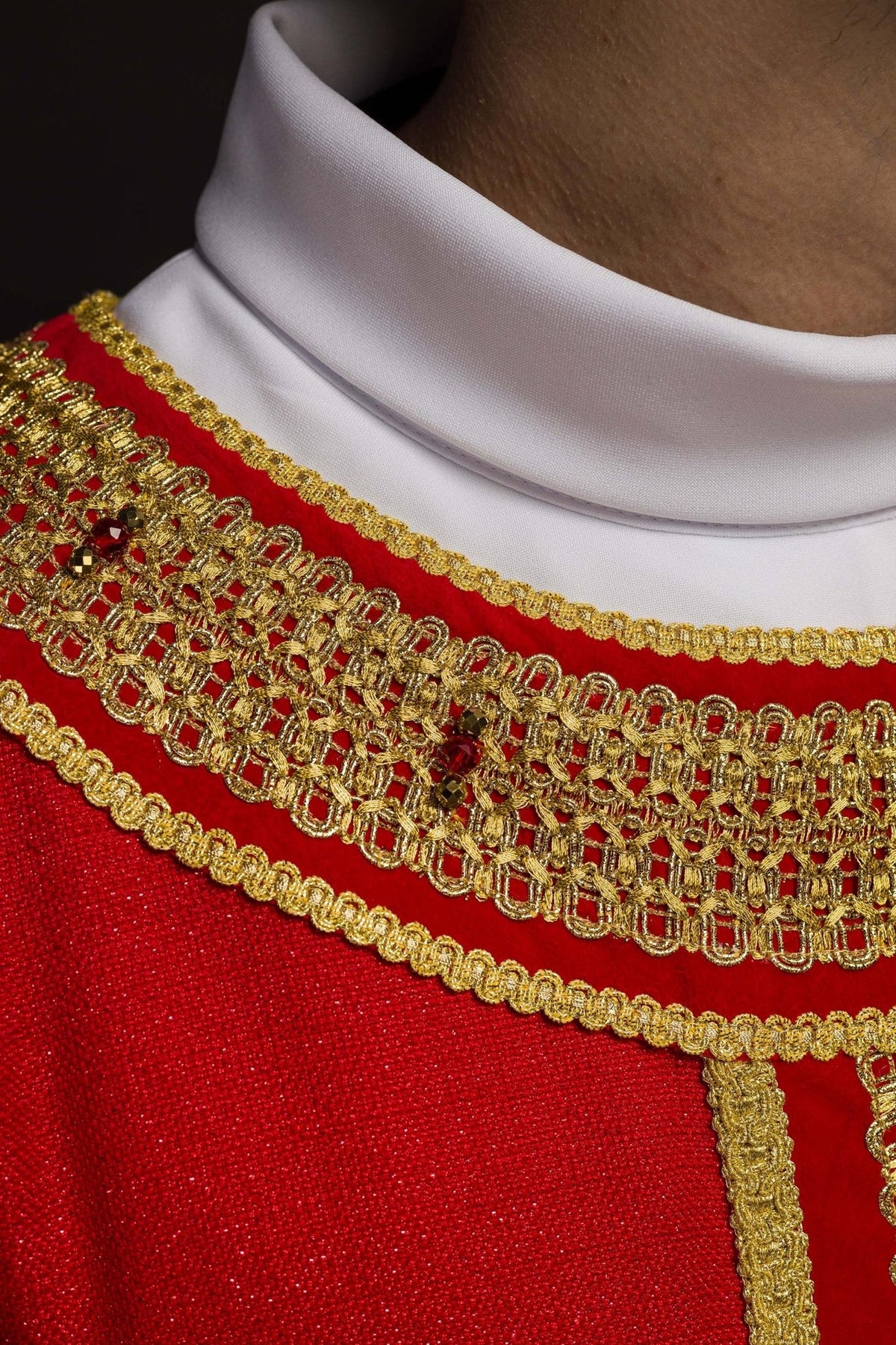 Red chasuble collar close-up with gold embroidery and red natural stones