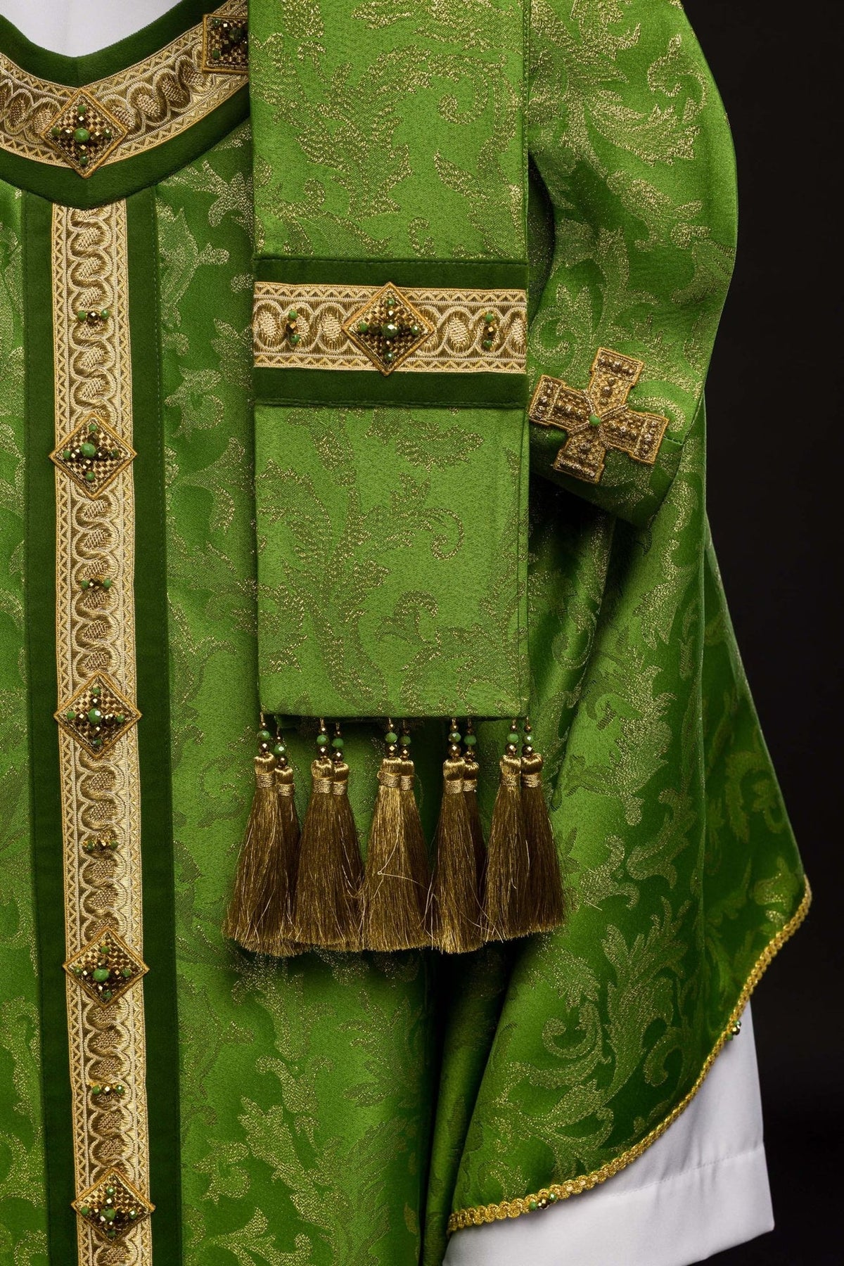 Green chasuble sleeve detail with gold embroidery, cross and tassel