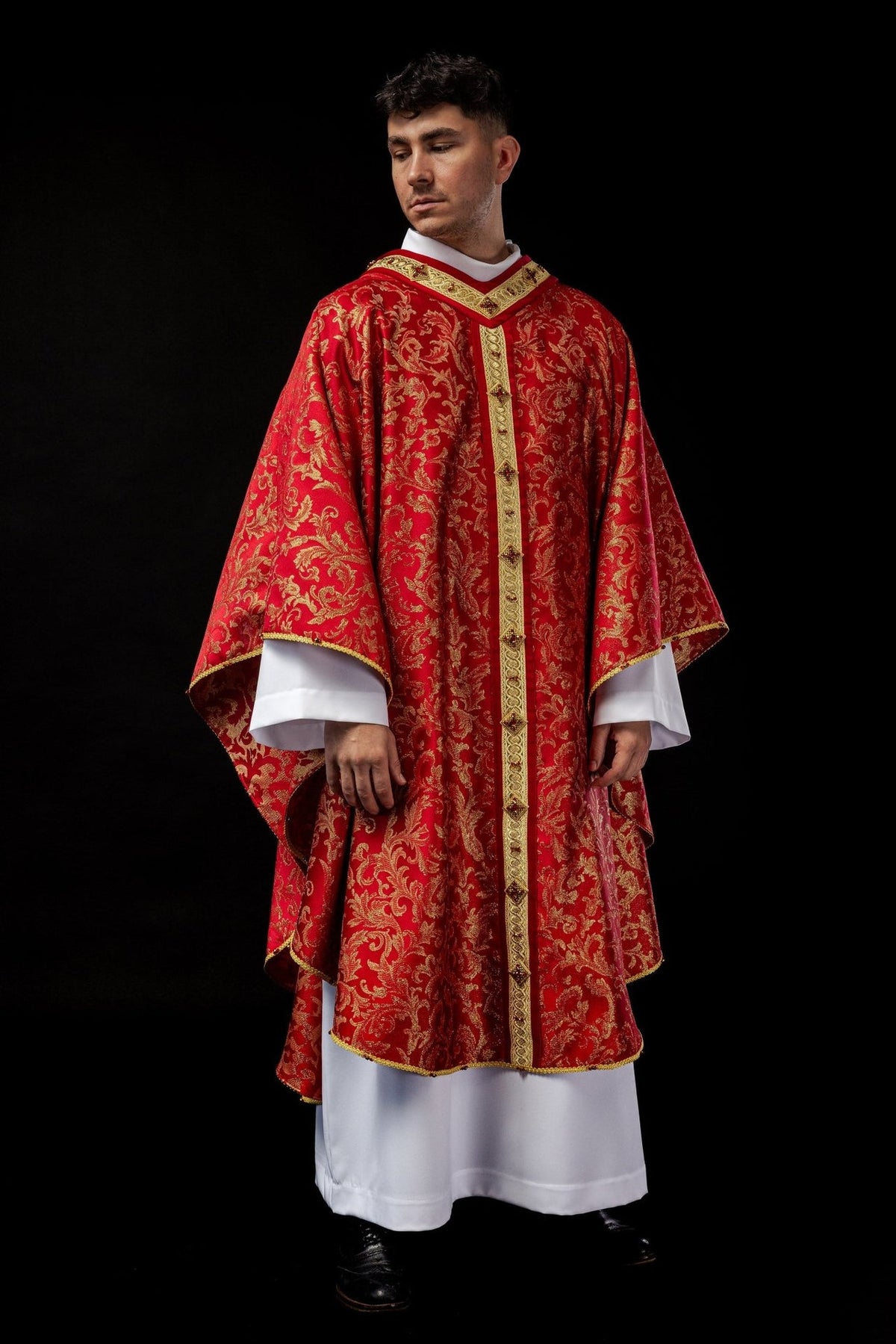 Handcrafted chasuble worn in full front view, red with gold floral embroidery and orphrey