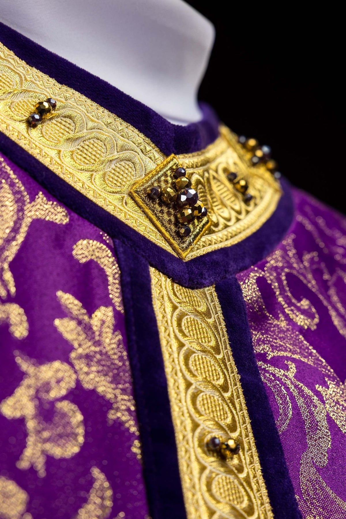 Chasuble close-up of gold orphrey with faceted natural stones and purple trim