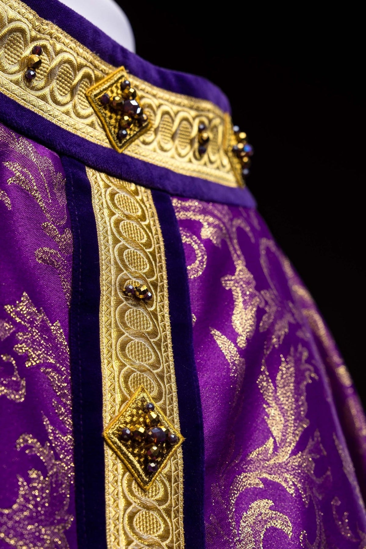 Chasuble close-up of gold cross embroidery with purple stones on purple jacquard