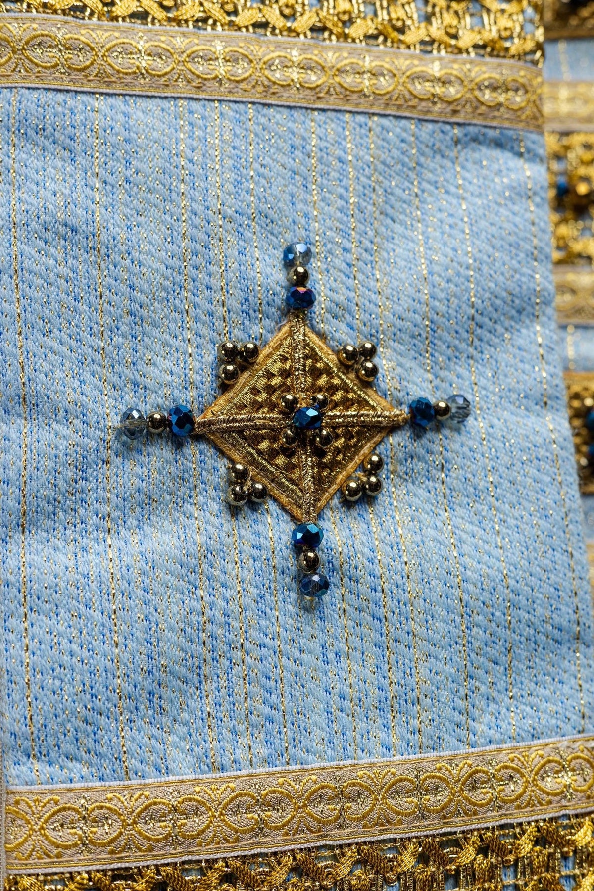 Marian chasuble, close-up of blue fabric, gold embroidery and beaded diamond motif