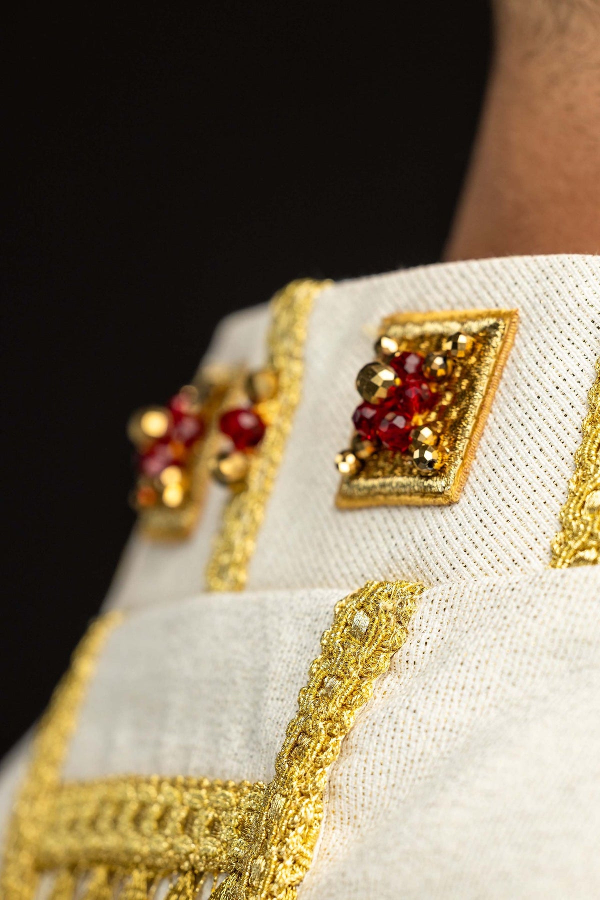 Handcrafted chasuble with natural stones, close-up of red stones and gold trim