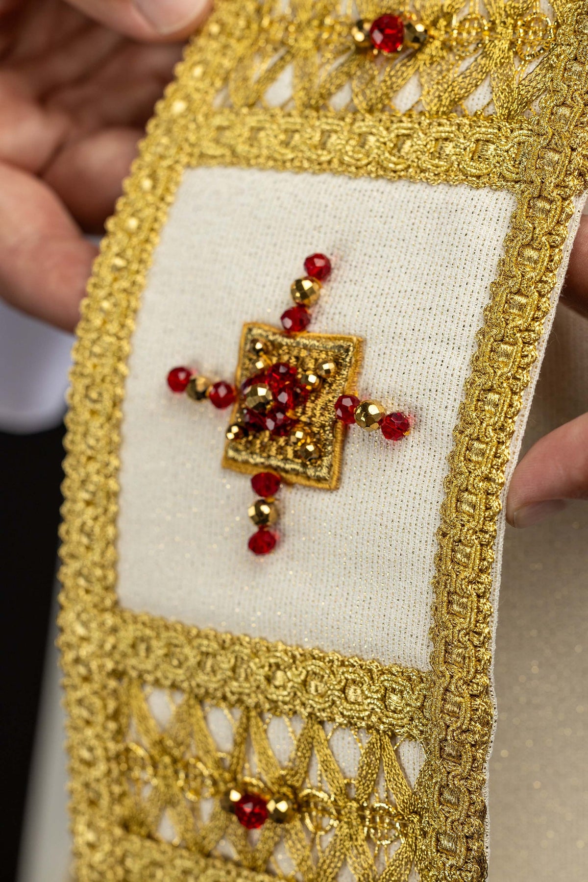 Handcrafted chasuble front panel close-up with a beaded cross and gold openwork bands