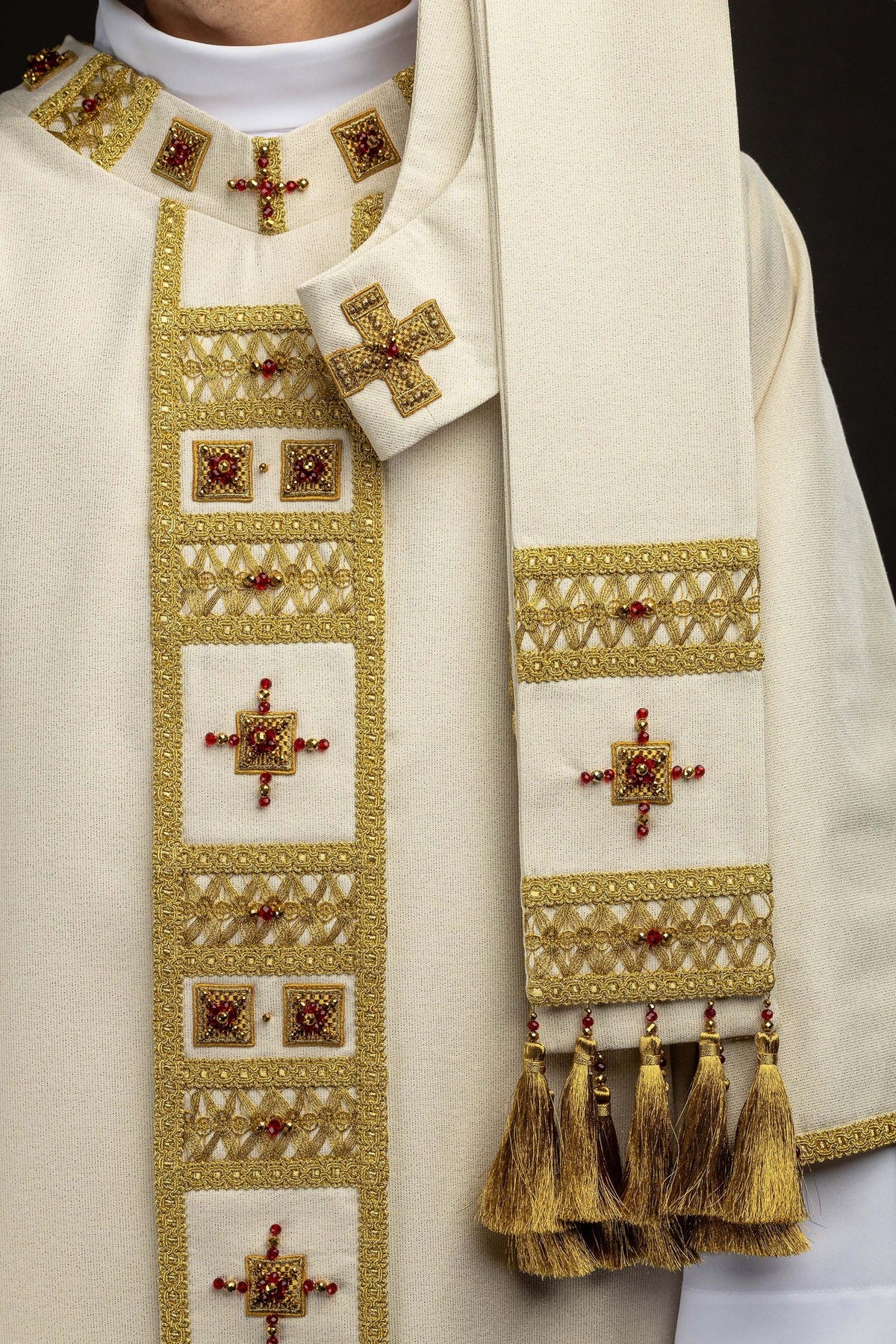 Handcrafted chasuble front and sleeve details with matching gold trim, beaded crosses, and tassels