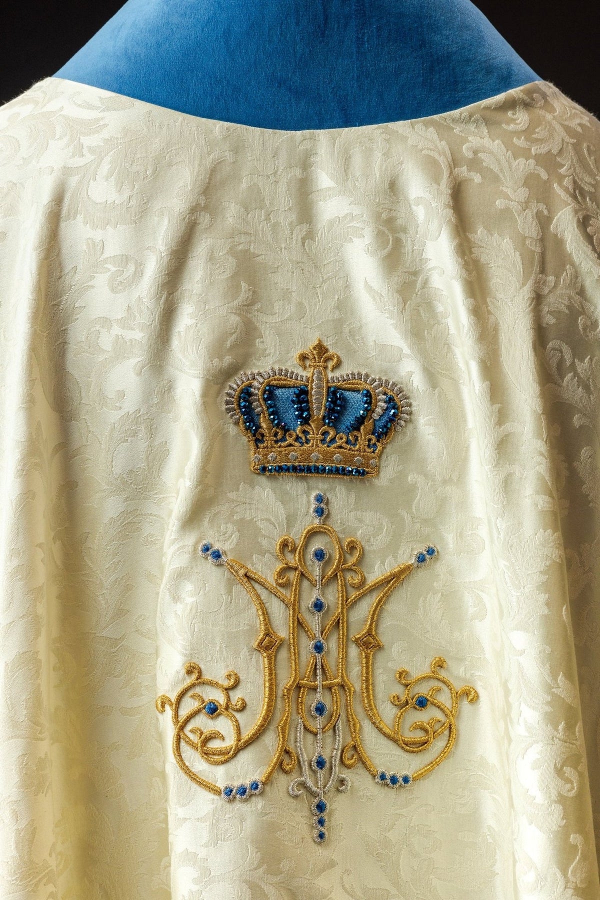 Marian chasuble detail showing gold tassel, rose embroidery and blue velvet trim