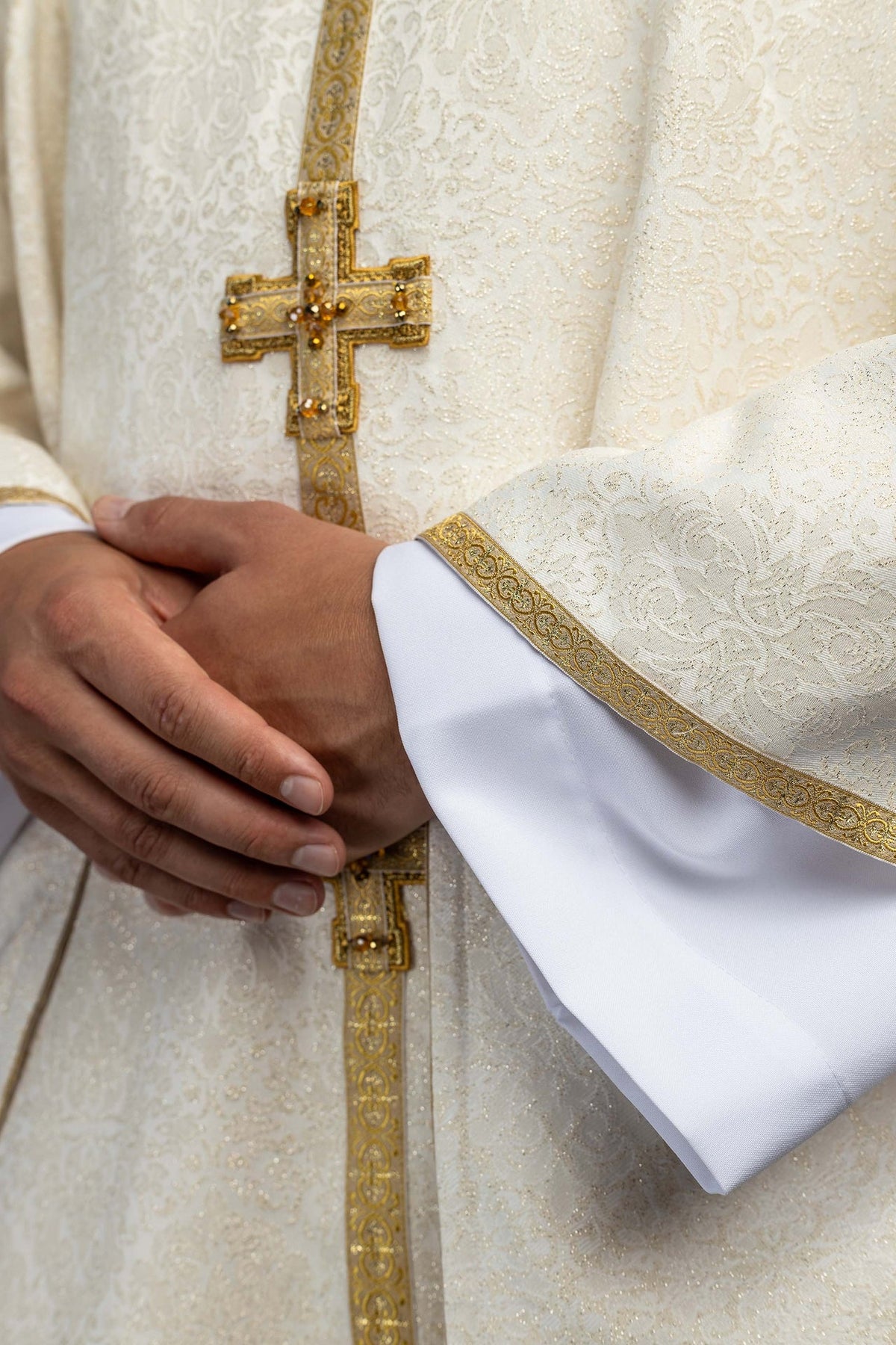 Ivory chasuble sleeve with gold edging and embossed scrolling pattern