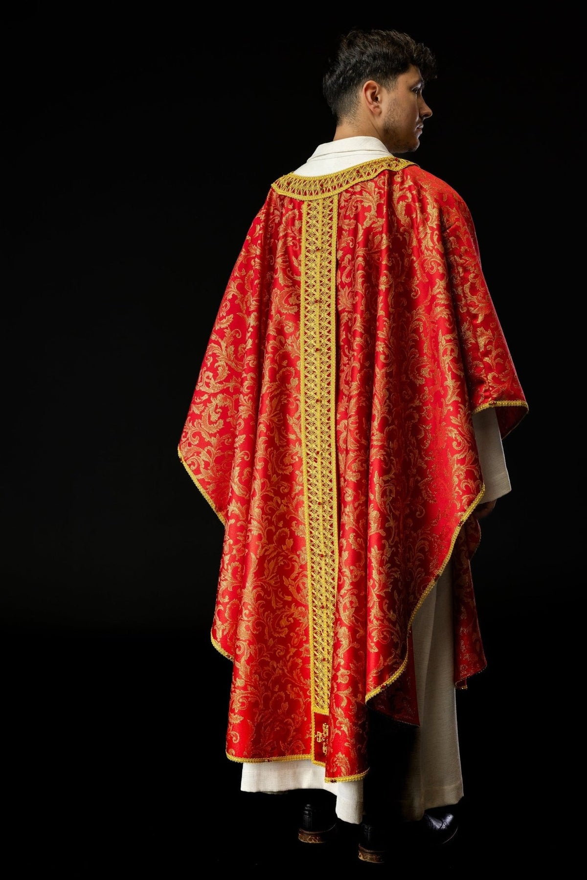 Red and gold chasuble rear three-quarter view with patterned fabric and orphrey