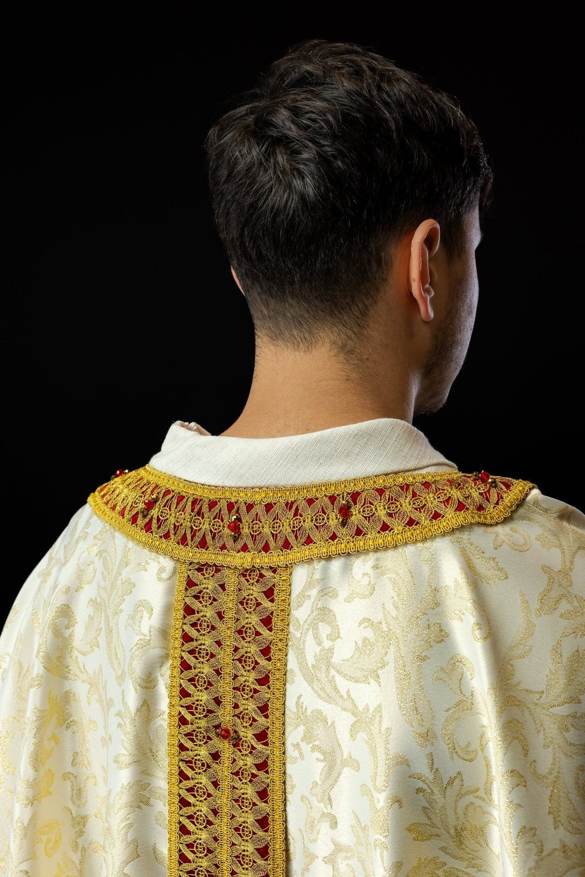 Handcrafted chasuble back close-up with red and gold orphrey and jeweled collar
