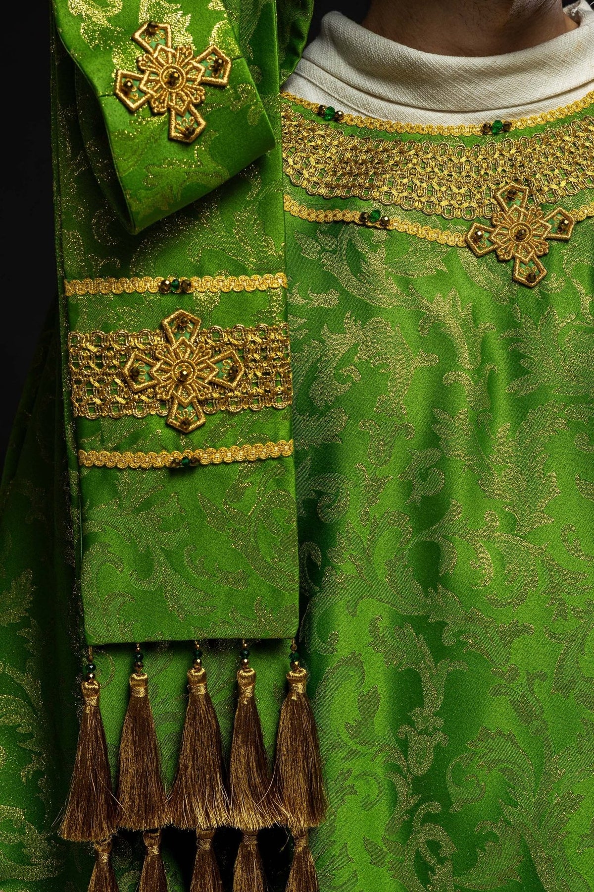 Green chasuble detail showing gold cross embroidery and hanging gold tassels