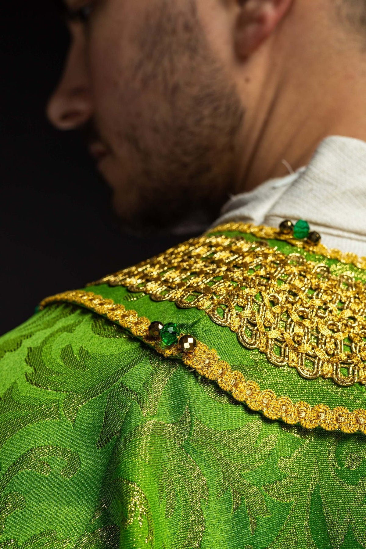Green chasuble neckline detail with gold embroidery and natural stones
