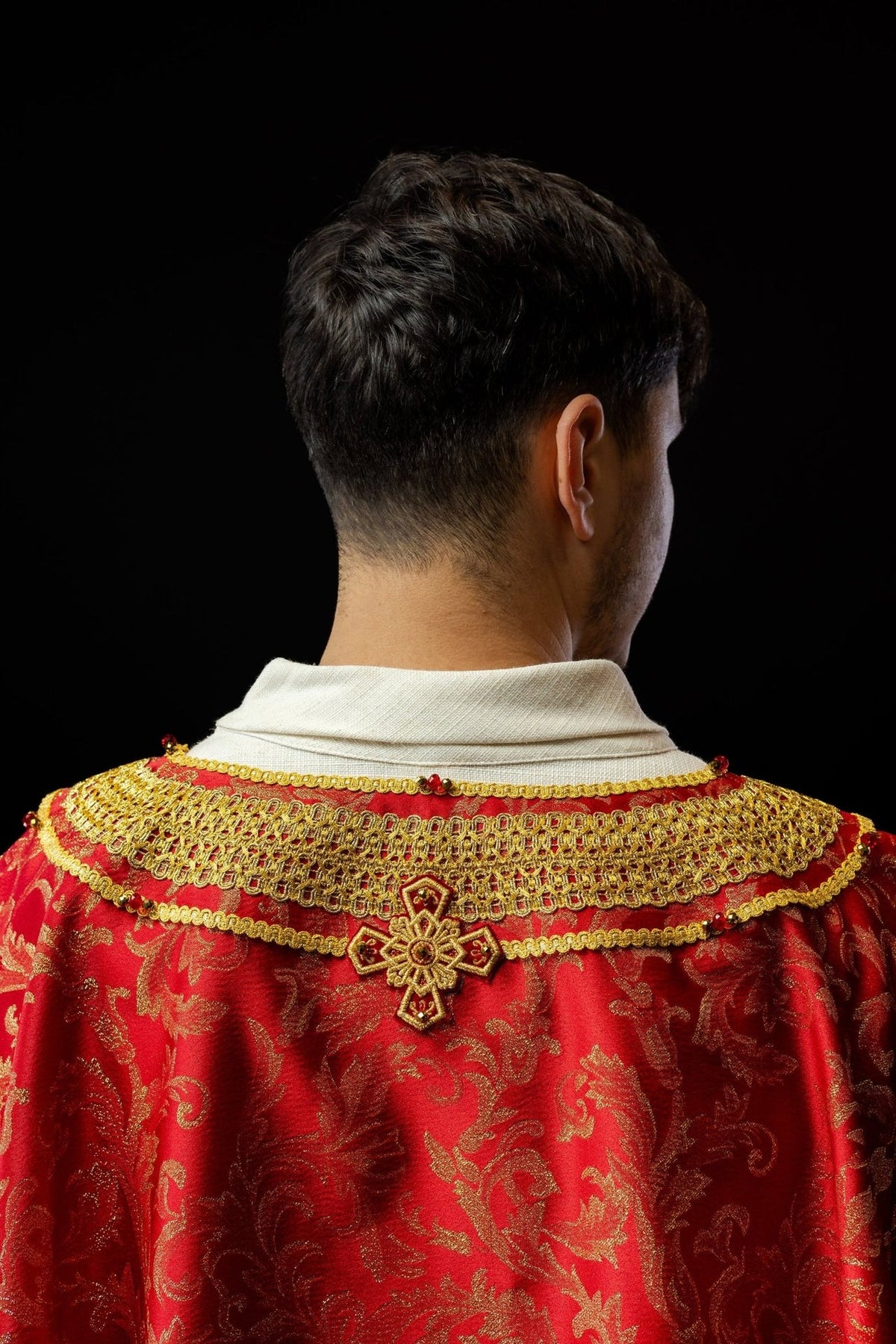 Red chasuble back close-up with gold collar embroidery and cross