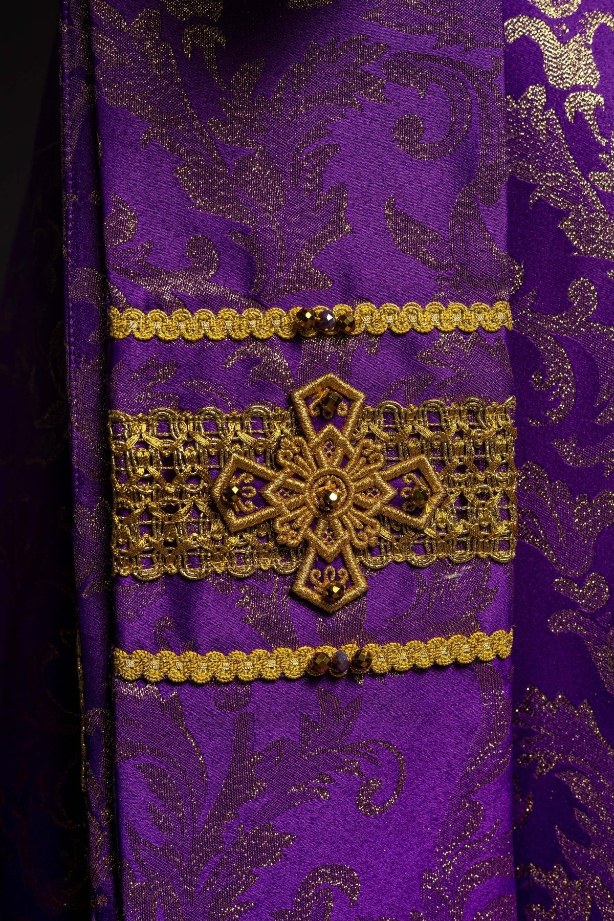 Purple chasuble sleeve detail with gold cross embroidery and floral jacquard fabric