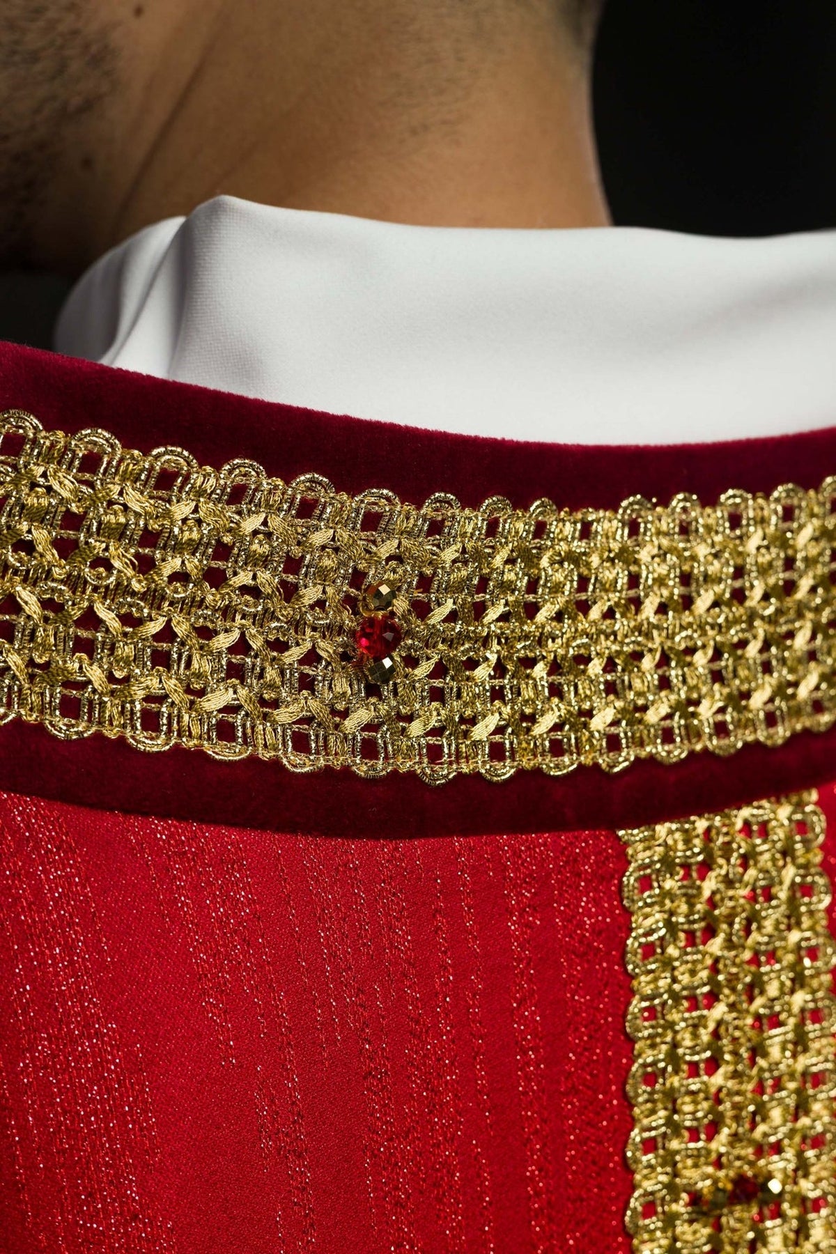 Red chasuble close-up of gold neckline embroidery with red natural stone