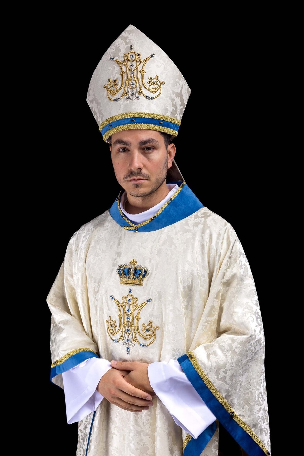Marian miter worn in three-quarter view with ecru fabric, blue band and gold embroidery