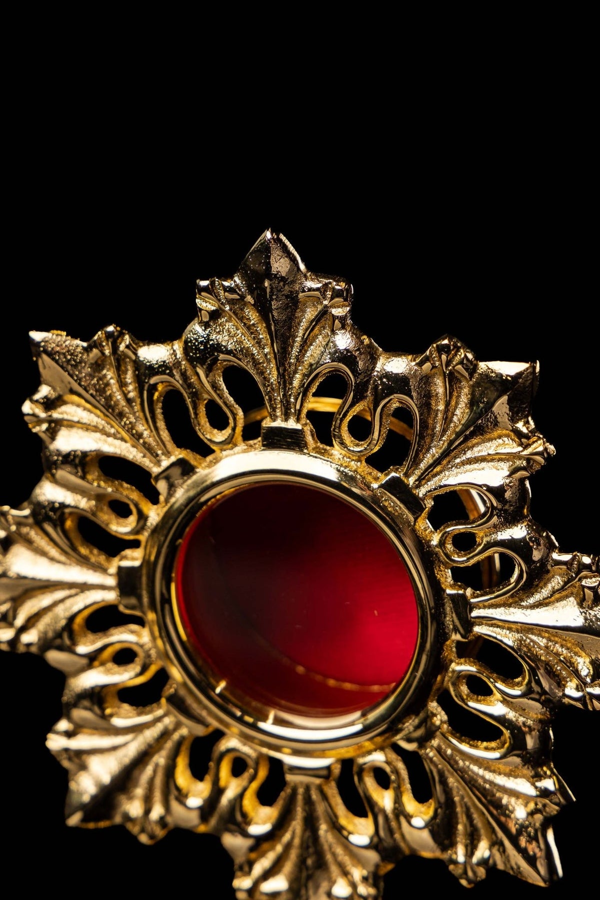 Brass reliquary close-up of red center and surrounding leaf motifs