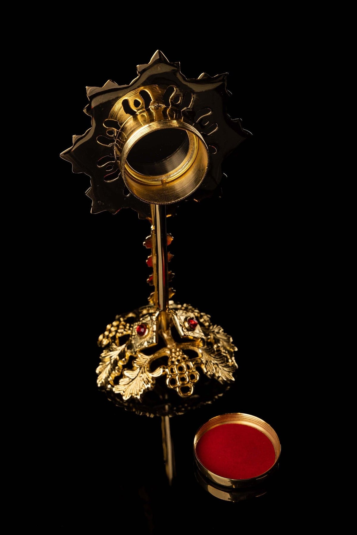 Brass reliquary back view with open central holder and ornate base