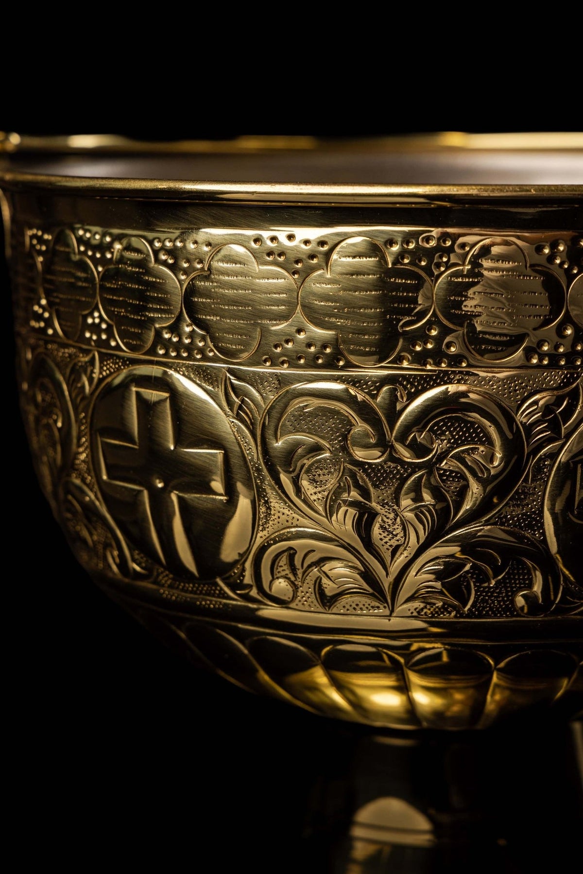 Brass holy water bucket detail with engraved cross, floral motifs and dotted patterned band