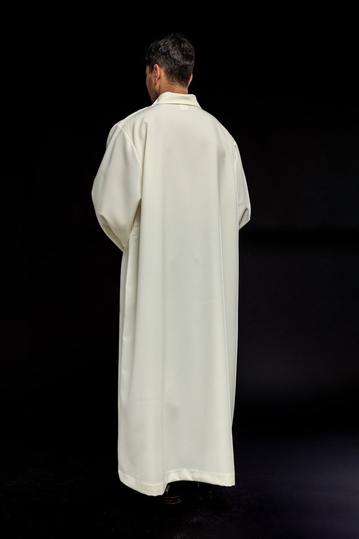 Ecru priest alb worn from the back, showing the full length and plain design