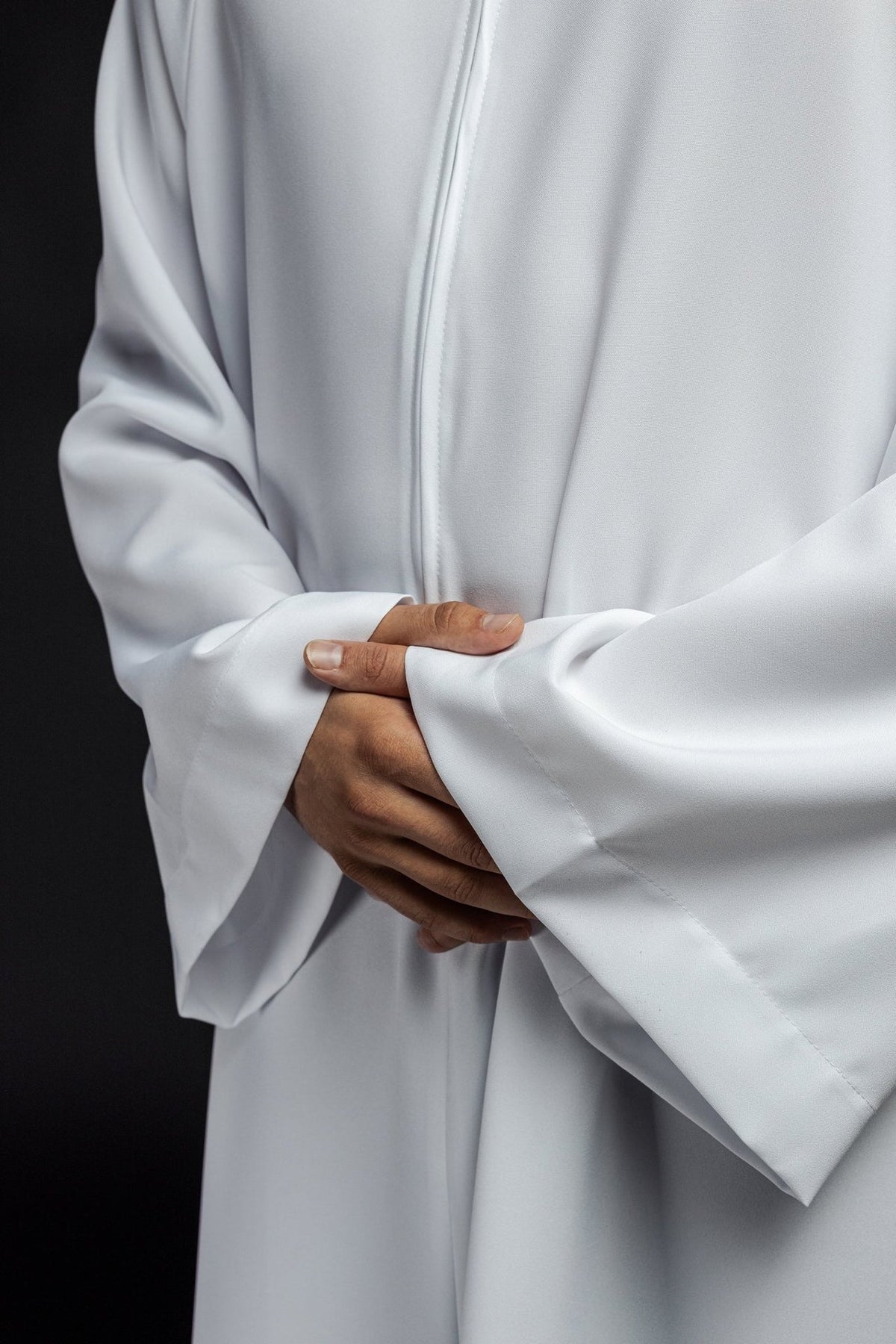 White priest alb close-up showing the wide sleeve cuffs