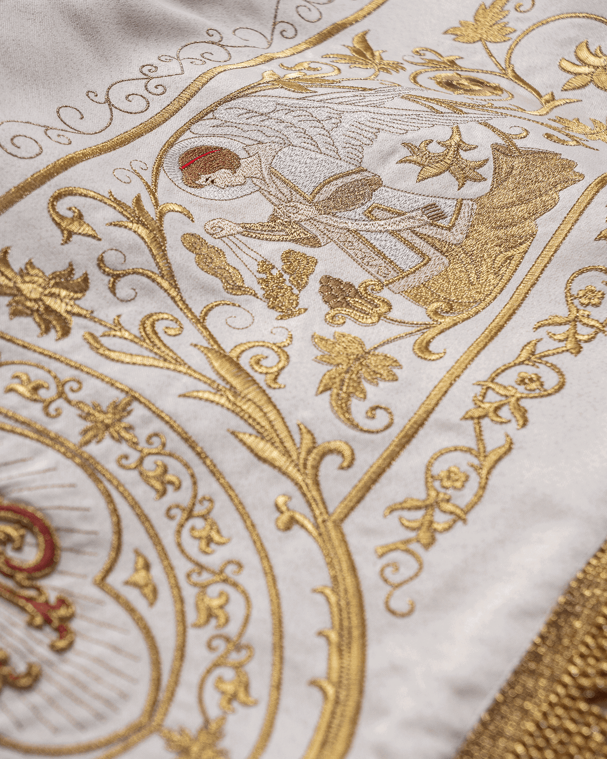 Corpus Christi processional canopy close-up with gold embroidered angel motif on ecru fabric